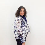 Woman wearing a patterned jacket against a white background