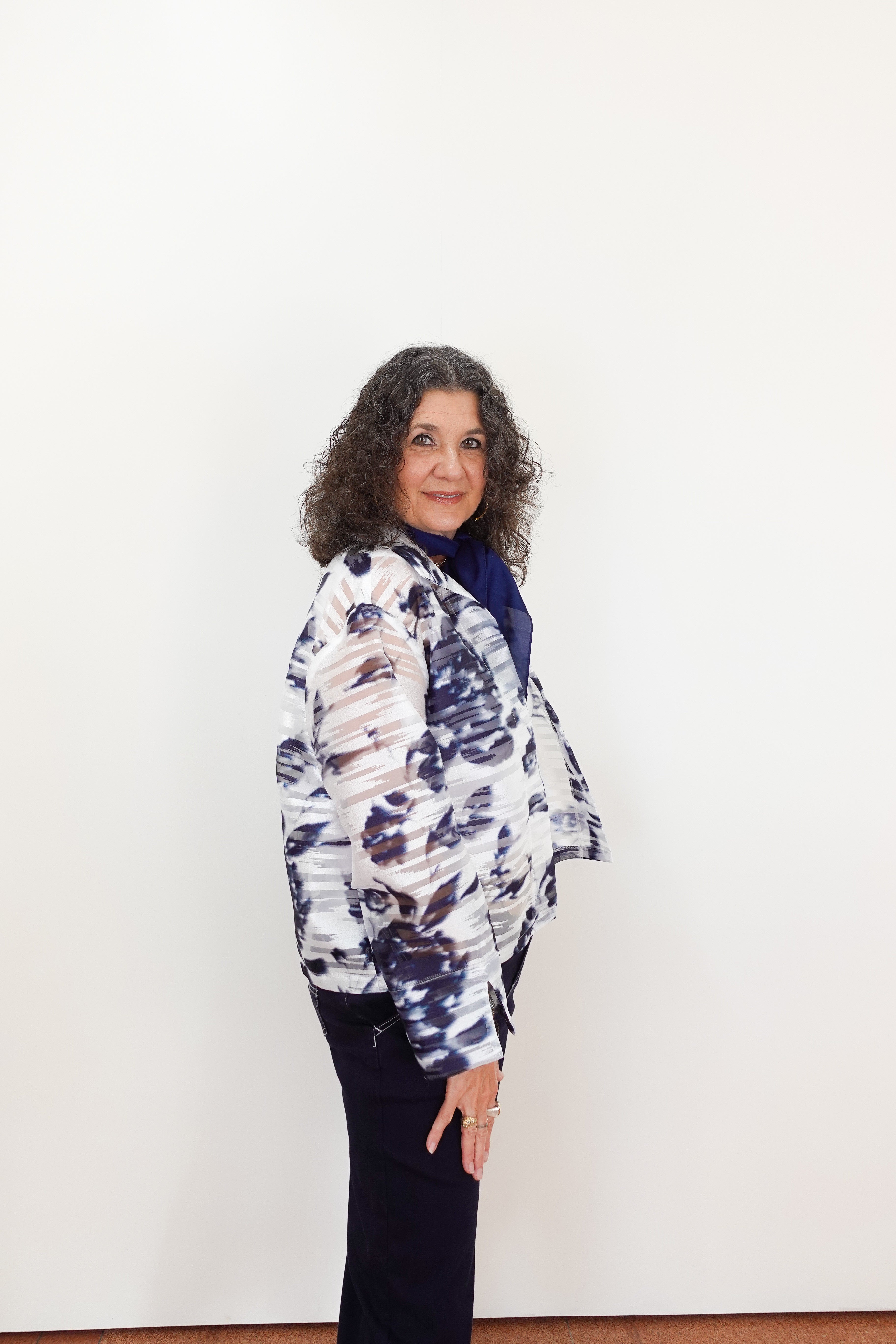 Woman wearing a patterned jacket against a white background