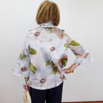 Person wearing a floral blouse with a plain background