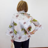 Person wearing a floral blouse with a plain background