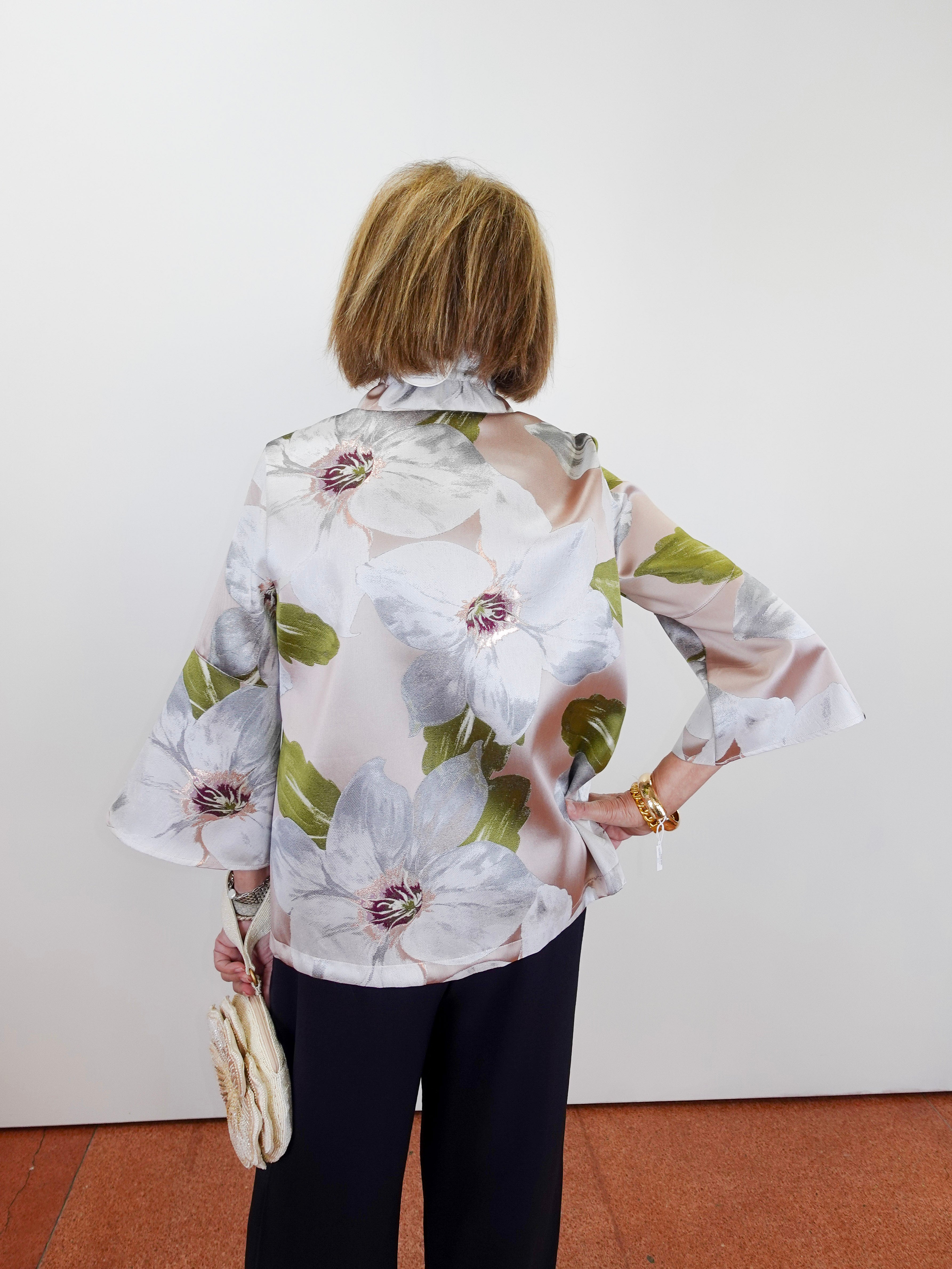 Person wearing a floral blouse with a plain background