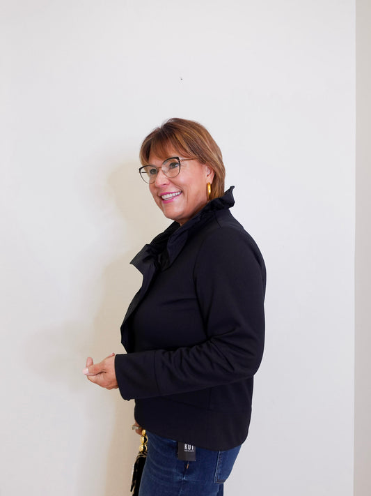 Woman wearing a black coat against a white background