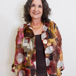 Woman wearing a colorful patterned jacket against a white background