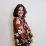 Woman wearing a patterned blouse against a white background