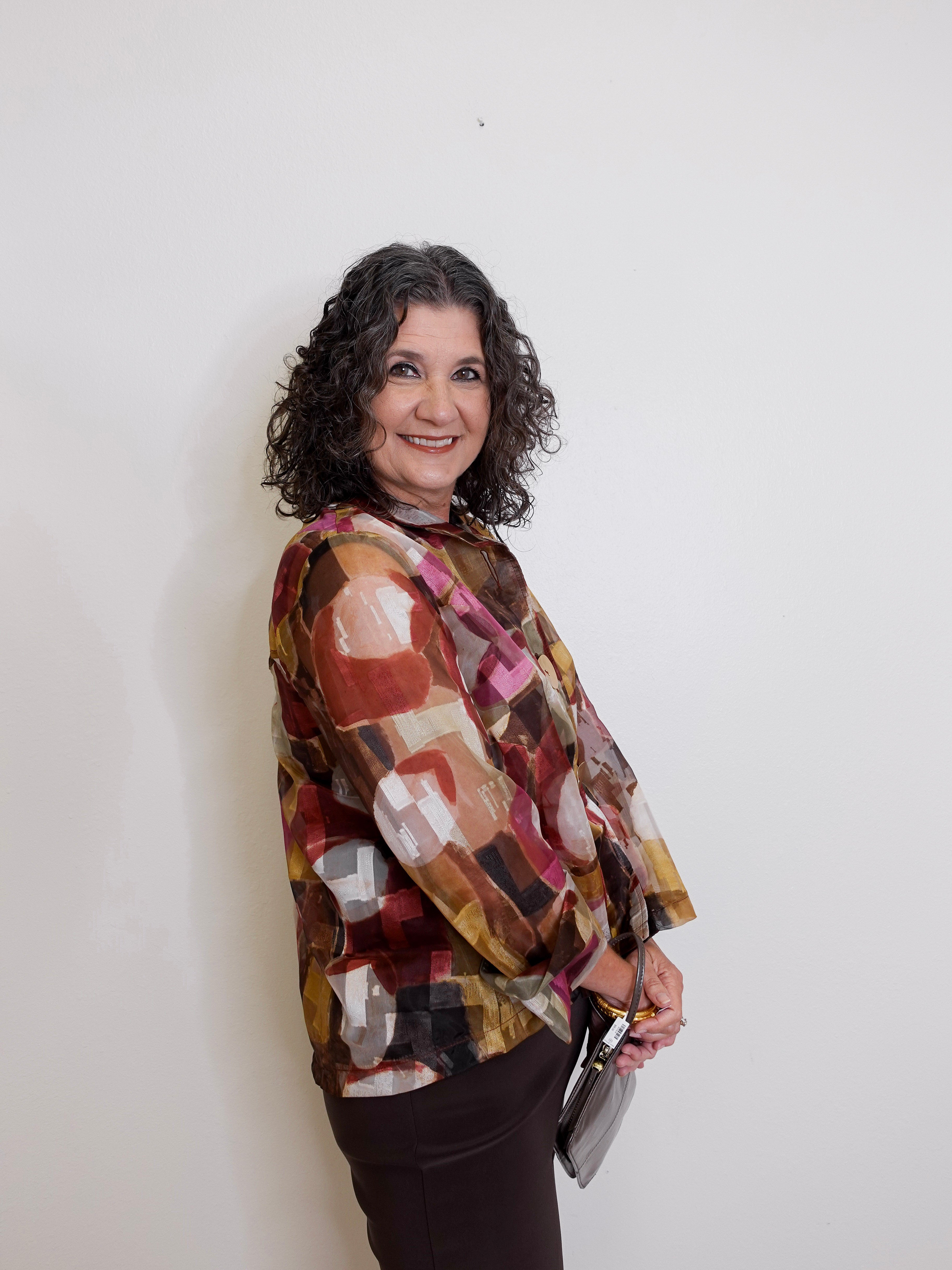 Woman wearing a patterned blouse against a white background