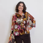 Woman wearing a colorful patterned jacket against a white background