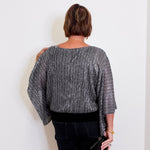 Person wearing a gray textured top against a white background