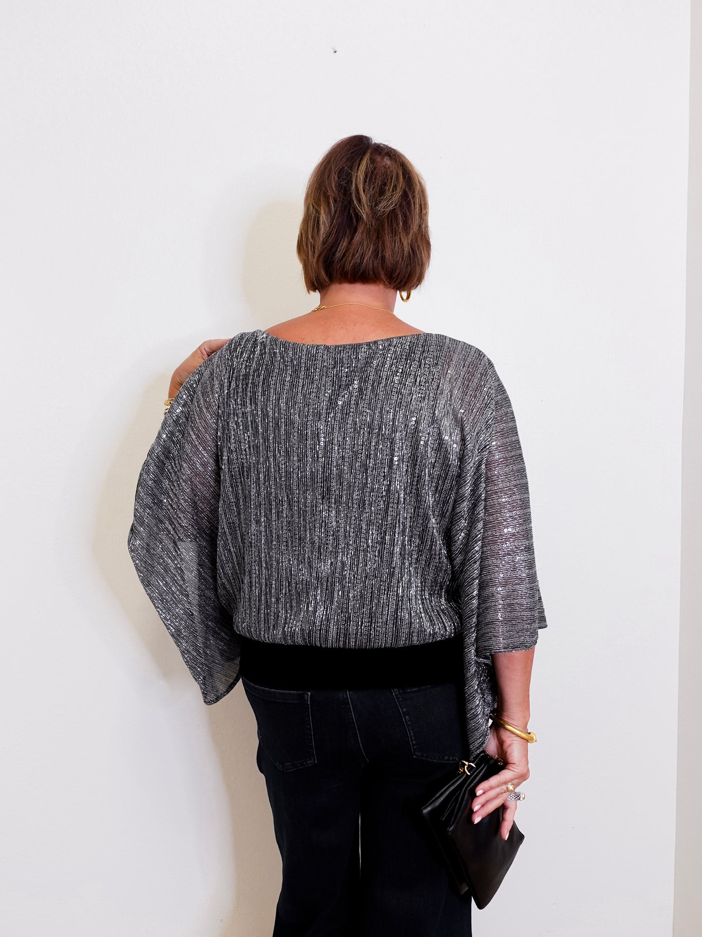 Person wearing a gray textured top against a white background