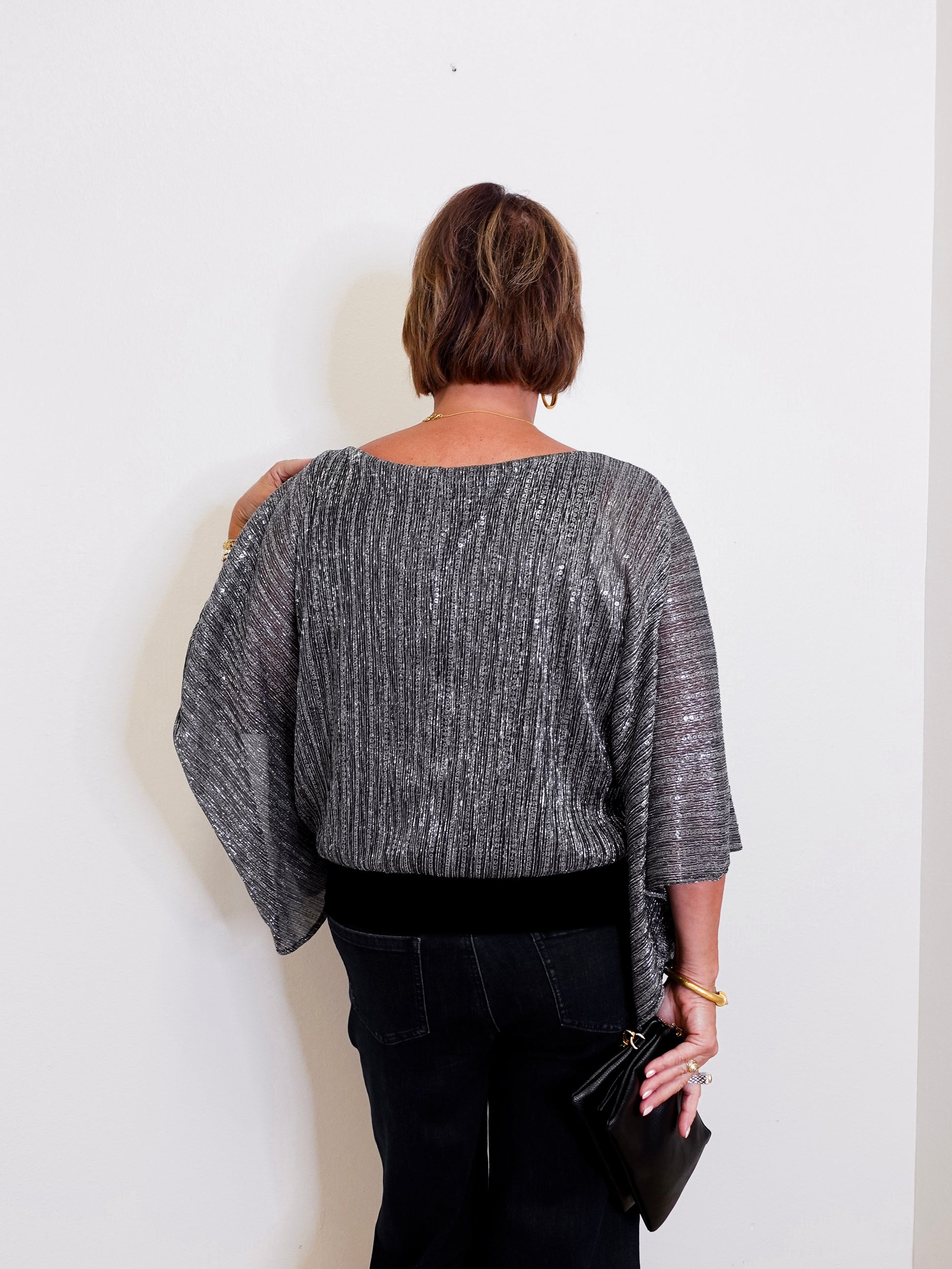 Person wearing a gray textured top against a white background