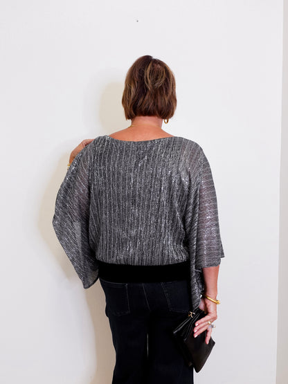 Person wearing a gray textured top against a white background