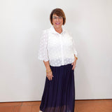 Model wearing a Joseph Ribkoff white polka dot blouse with sheer sleeves and button-front design.