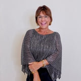 Woman wearing a sparkly gray top against a plain background