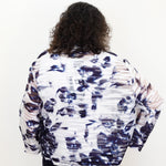 Person wearing a patterned jacket on a white background