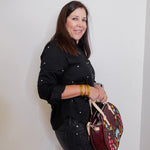 Woman holding a colorful backpack against a plain background