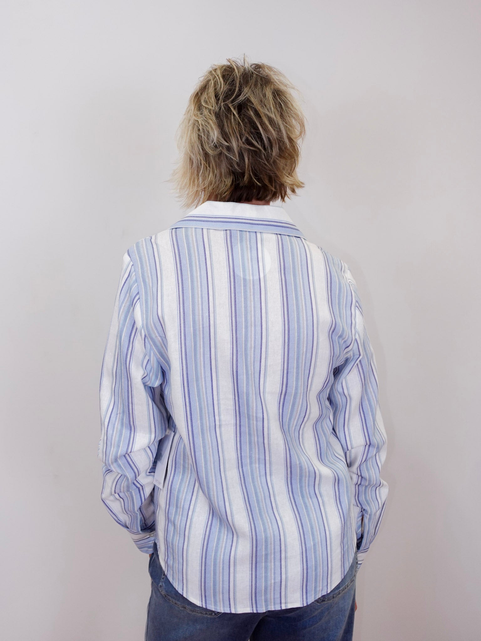 karen kane long sleeve lace up top featuring a striped pattern and lace up neckline worn by model