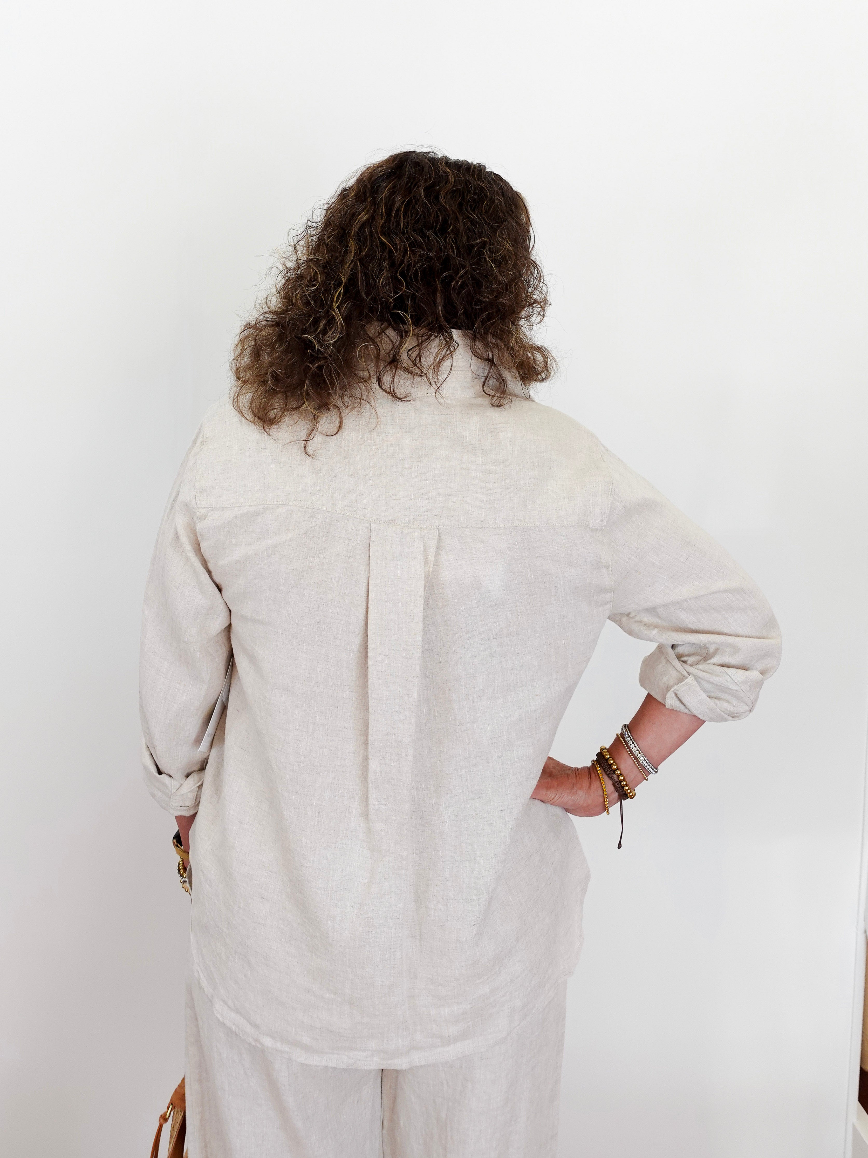 Person wearing a light-colored outfit against a white background