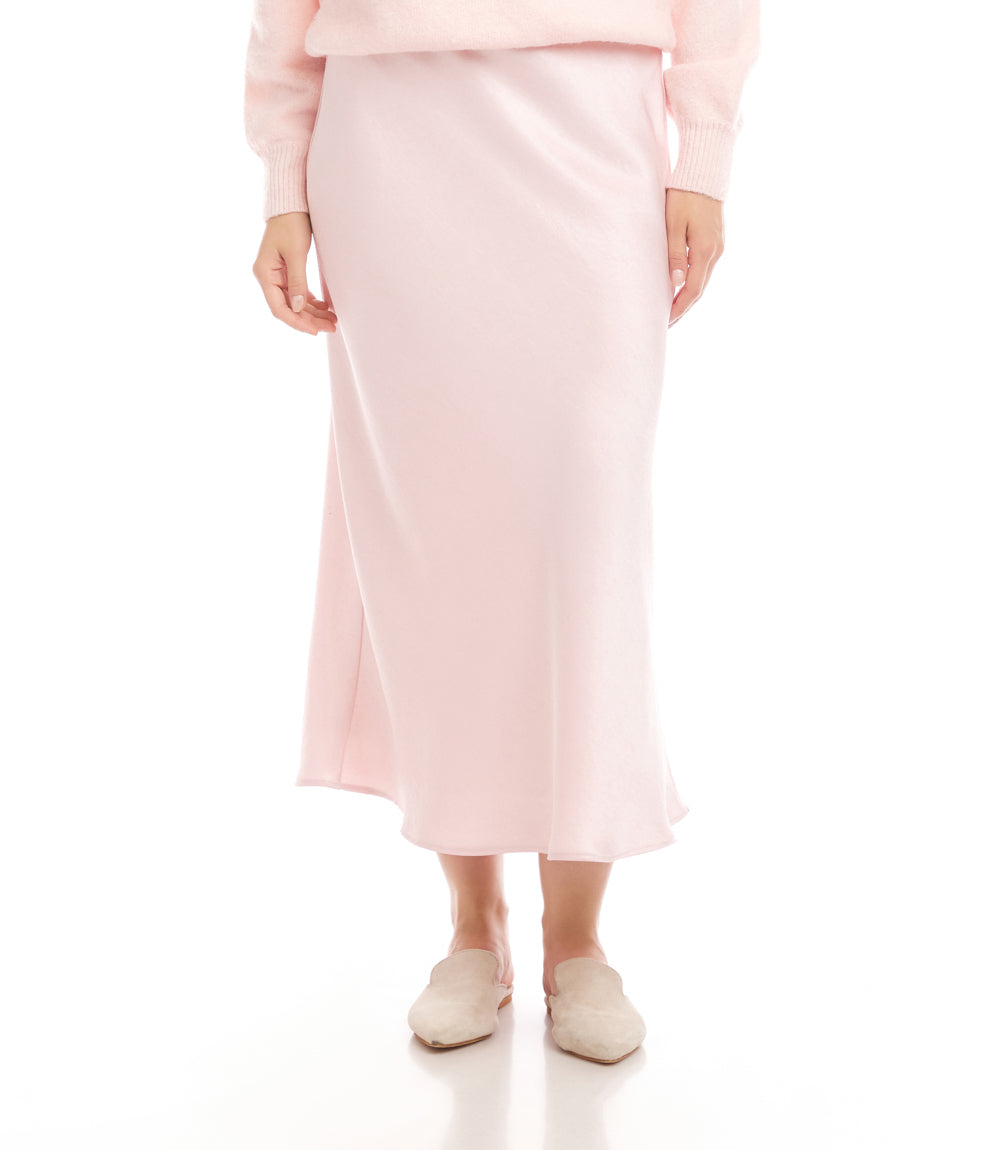 Person wearing a light pink skirt and top on a white background