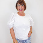 model wearing the karen kane white puff sleeve embroidered top with eyelet detail