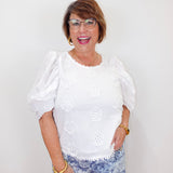 model wearing the karen kane white puff sleeve embroidered top with eyelet detail