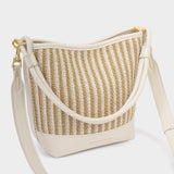 Woven handbag with beige strap on a white background