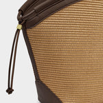 Close-up of a brown textured bag with a strap on a light gray background