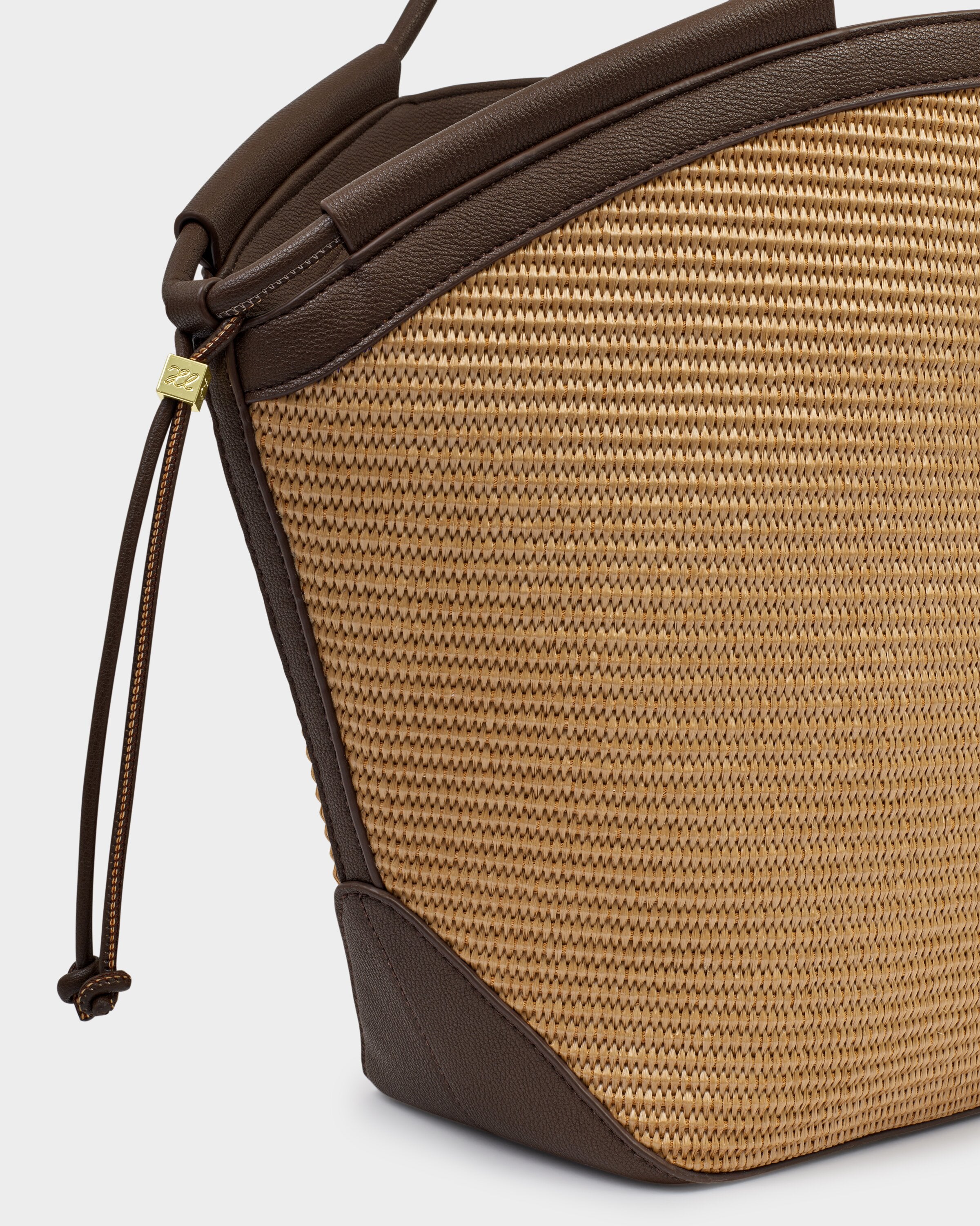 Close-up of a brown textured bag with a strap on a light gray background