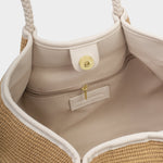 Close-up of a beige handbag with braided handle and interior details.