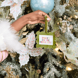Hand holding a photo frame ornament on a decorated Christmas tree
