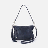 Navy blue handbag with a strap on a light gray background