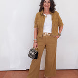 Woman in a brown outfit with a white wall background
