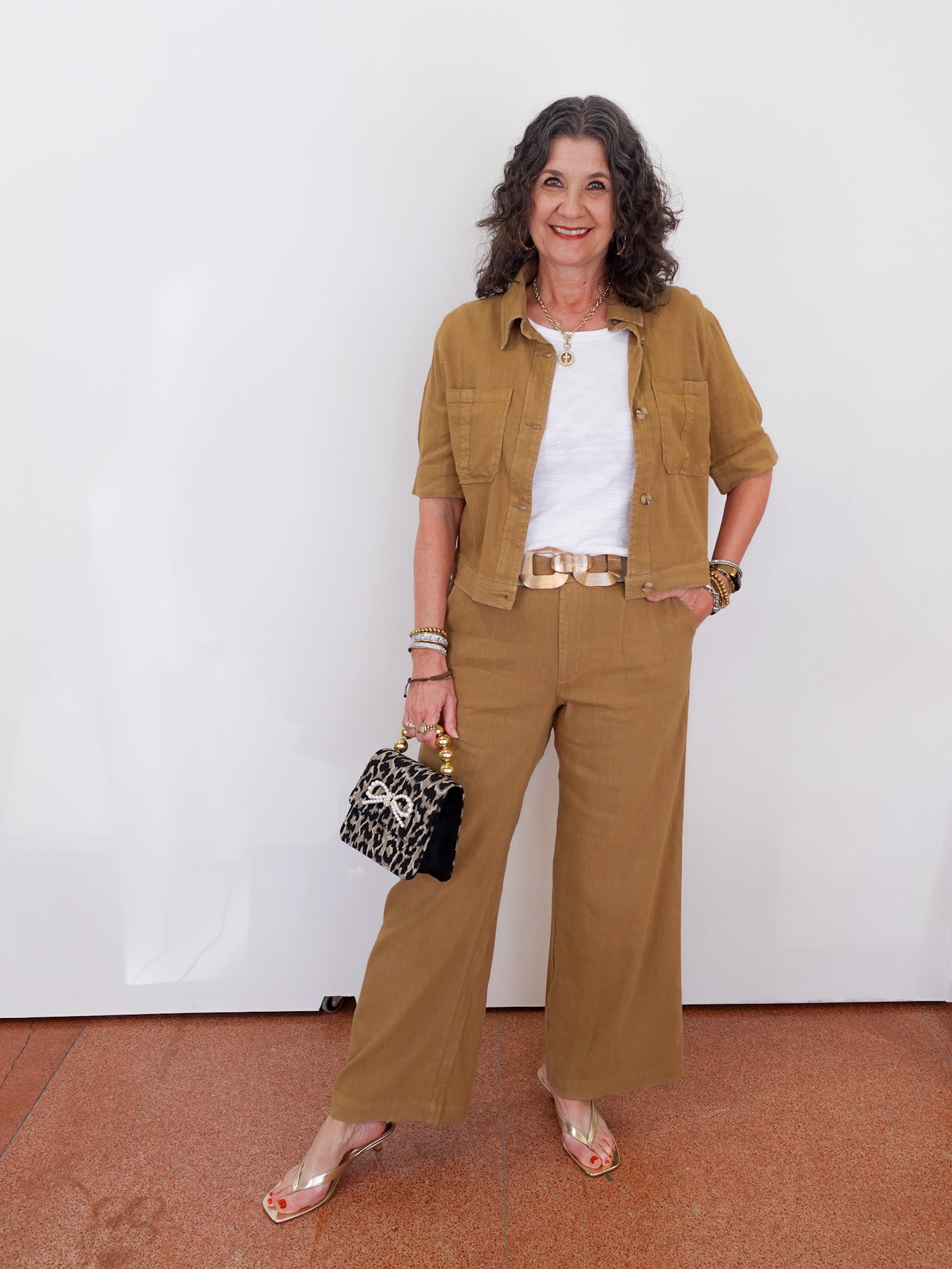 Woman in a brown outfit with a white wall background
