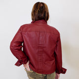 Person wearing a red leather jacket and camouflage pants against a white background