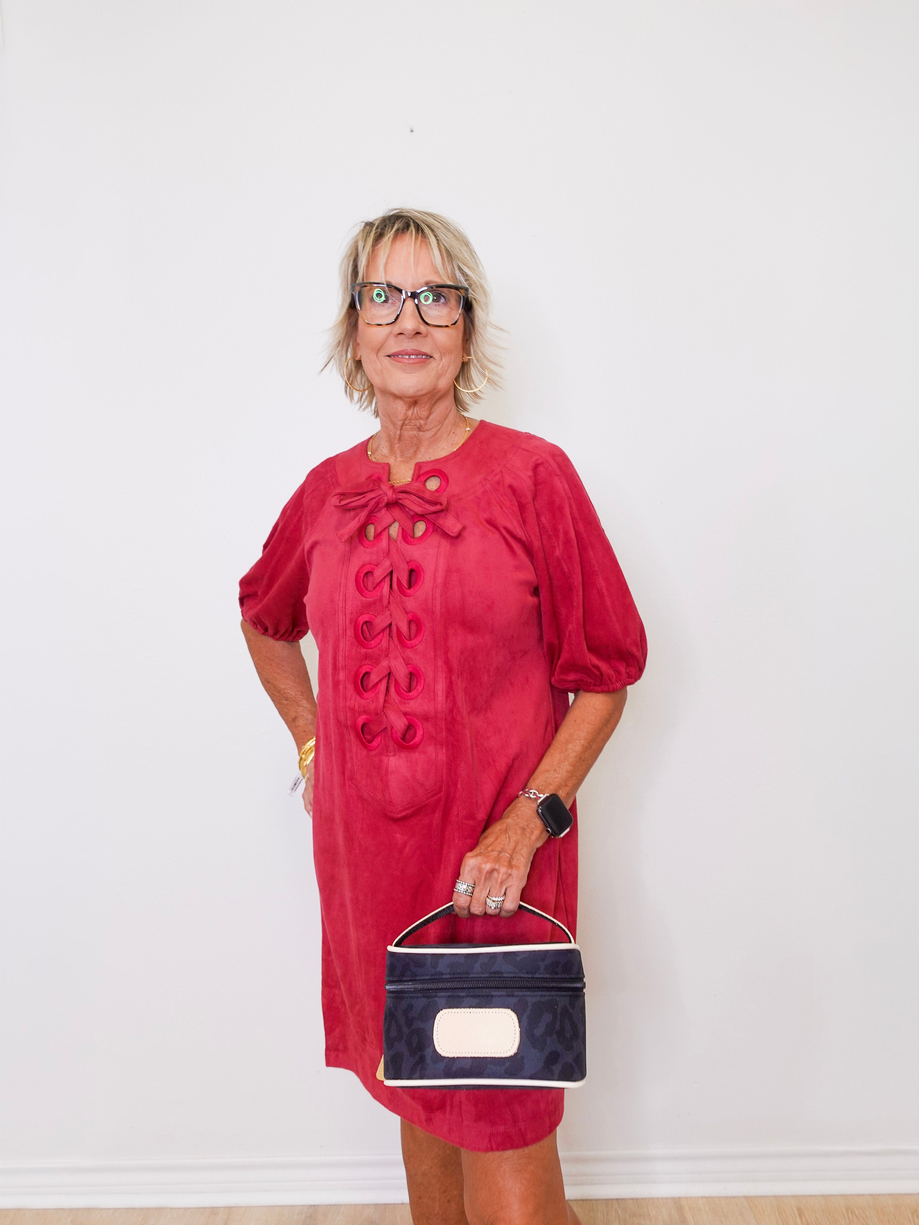 Woman wearing a red dress with puff sleeves against a white background