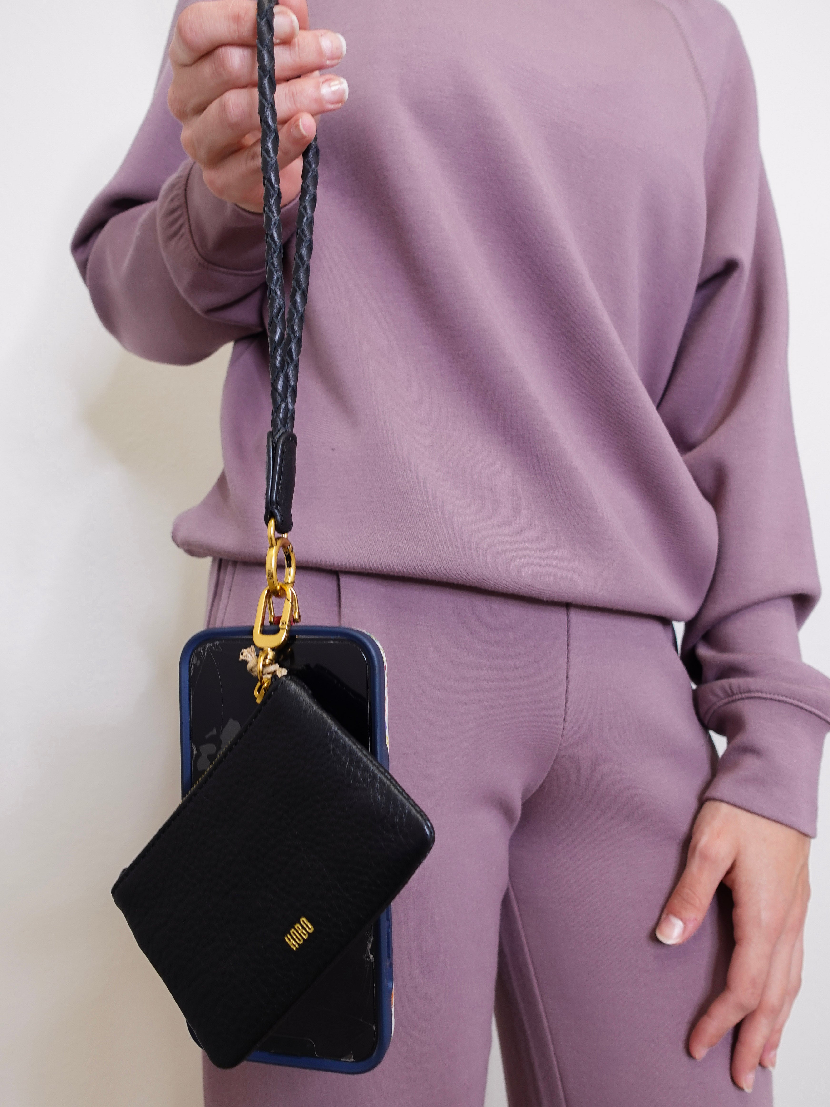 woman modeling the Hobo black phone wristlet 
