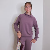 woman modeling the lasso phone wristlet in pebbled leather mulberry glaze color against a white background. 