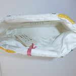 Close-up of a white garment with yellow trim on a light gray background