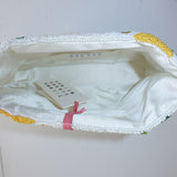 Close-up of a white garment with yellow trim on a light gray background