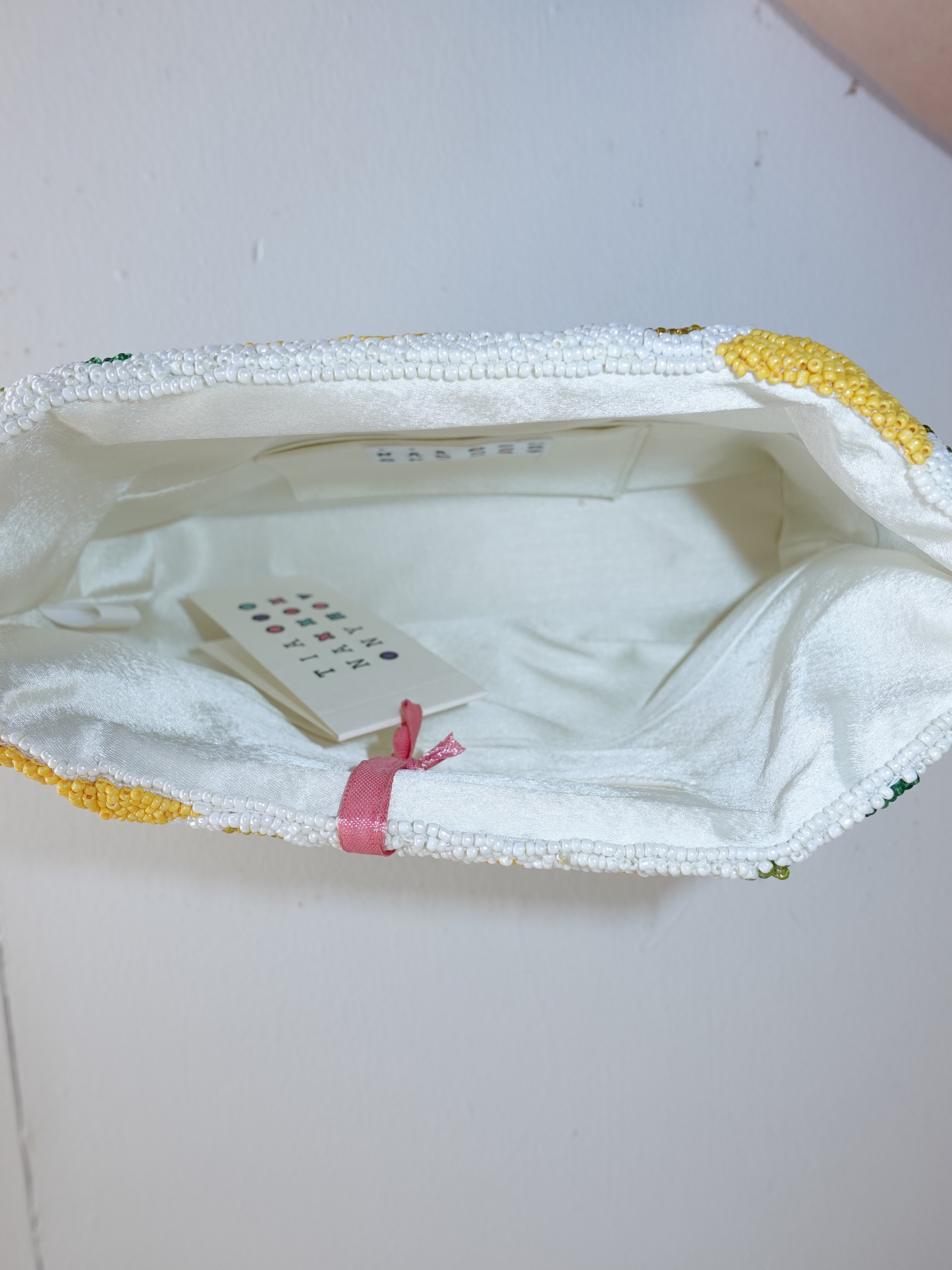 Close-up of a white garment with yellow trim on a light gray background