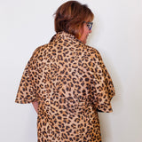 Person wearing a leopard print shirt against a white background