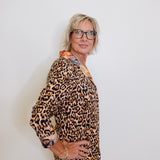 Person wearing a leopard print outfit with a plain background