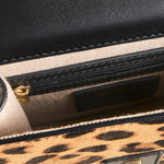 Close-up of a handbag with leopard print and black leather accents.