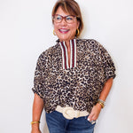 Woman wearing a leopard print blouse with a white background