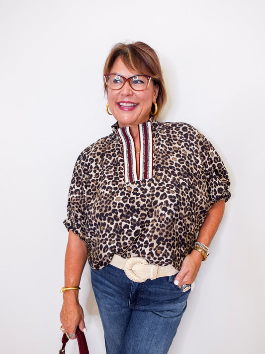 Woman wearing a leopard print blouse with a white background