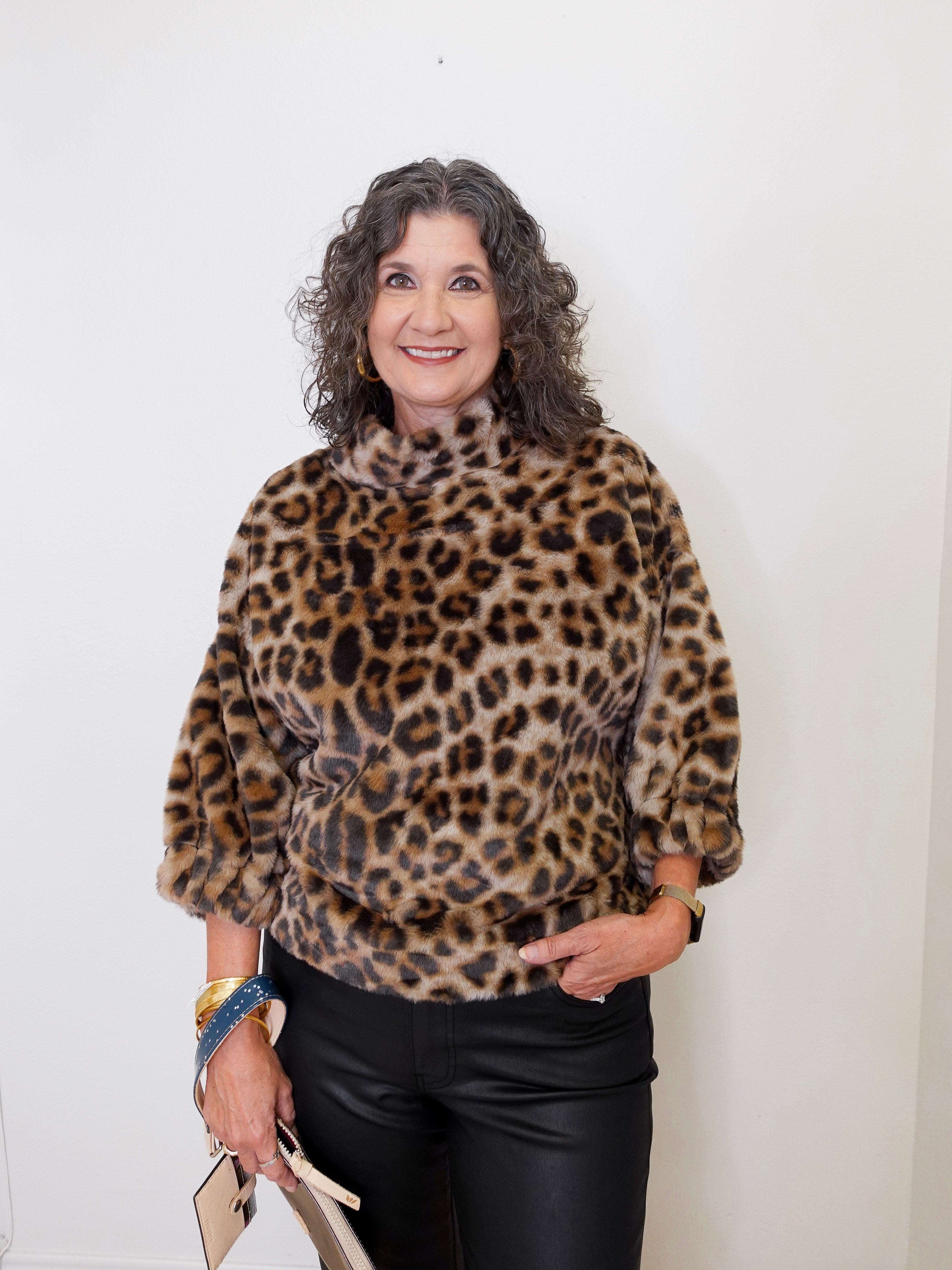 Woman wearing a leopard print sweater against a white background
