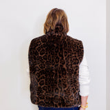 Person wearing a leopard print vest against a white background