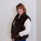 Person wearing a leopard print vest against a plain background