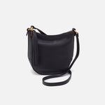 Black leather handbag with a strap on a light gray background