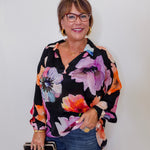Woman wearing a floral blouse with a plain background