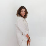 Woman wearing a light-colored outfit against a white background