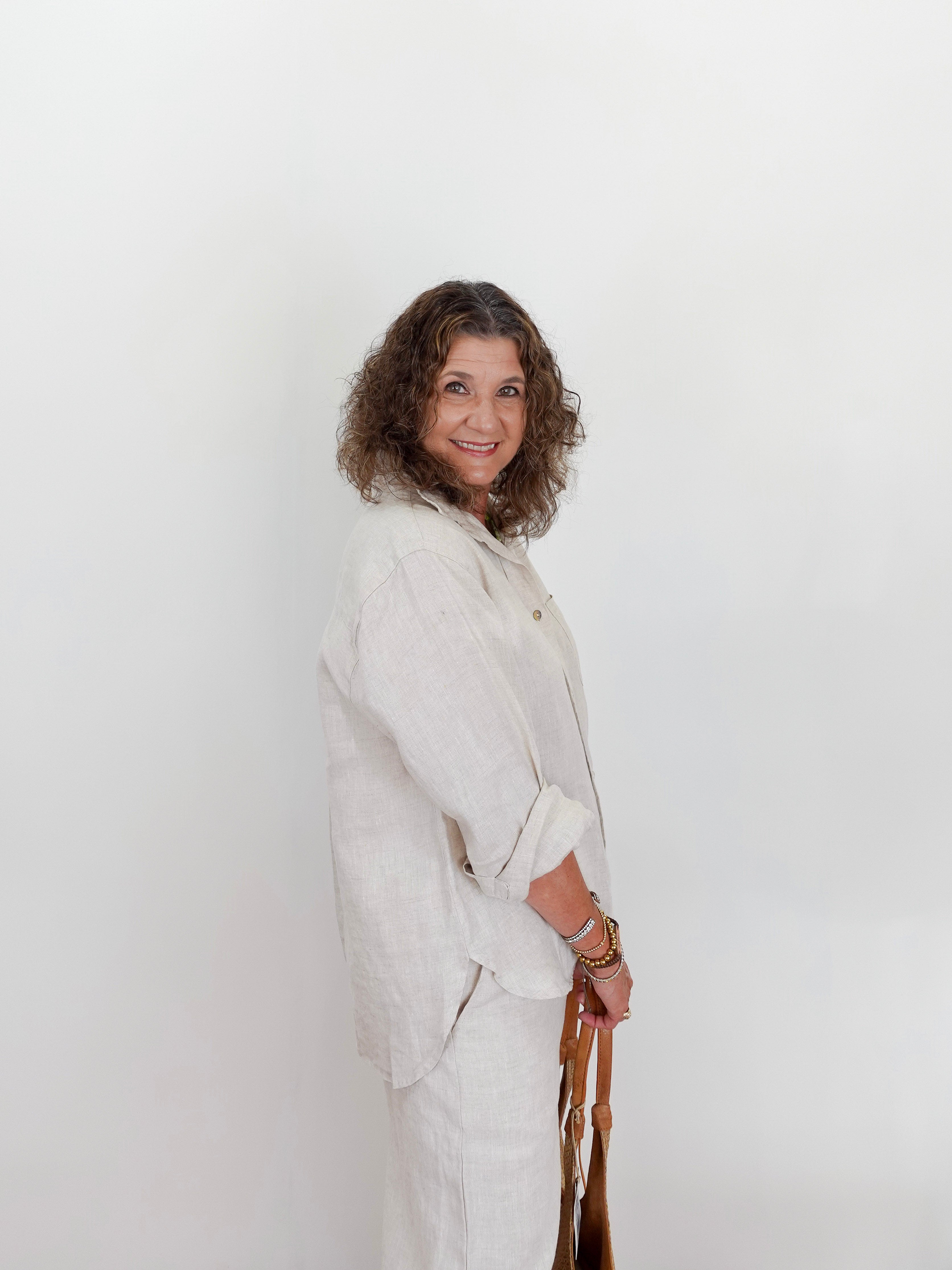Woman wearing a light-colored outfit against a white background